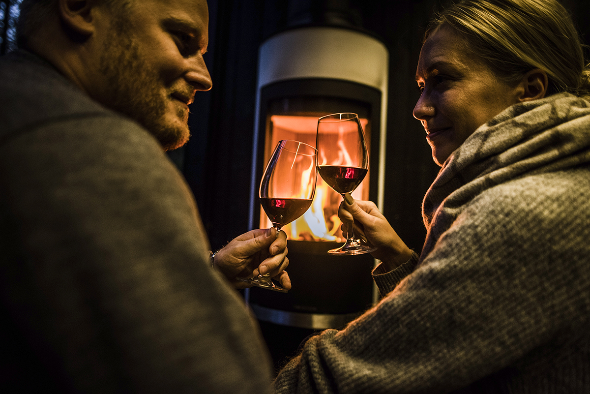 young coupleby the fire with wine glasses
