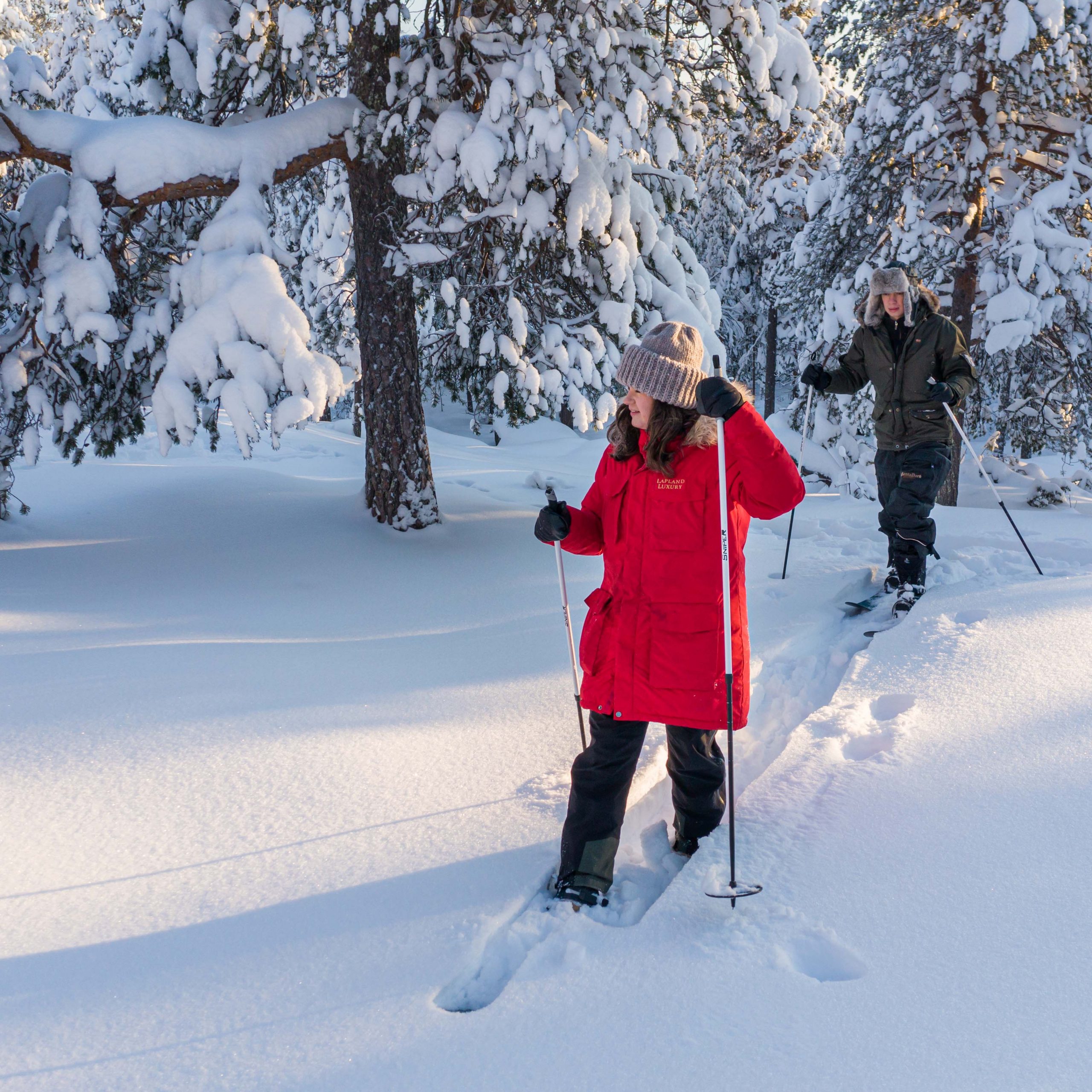 Couple snowshoeing in winter in Finnish Lapland.