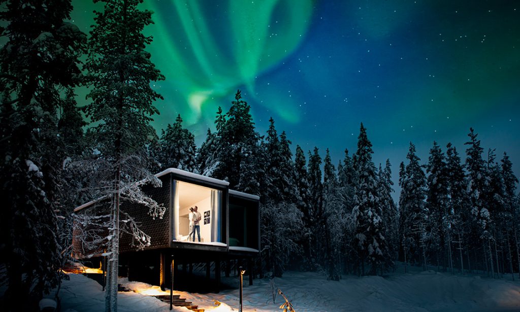 Couple in a romantic setting at Arctic TreeHouse Hotel under the northern lights