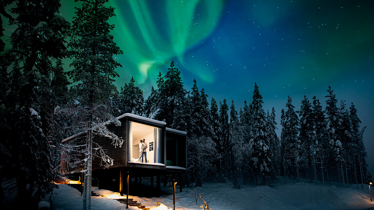 Couple in a romantic setting at Arctic TreeHouse Hotel under the northern lights