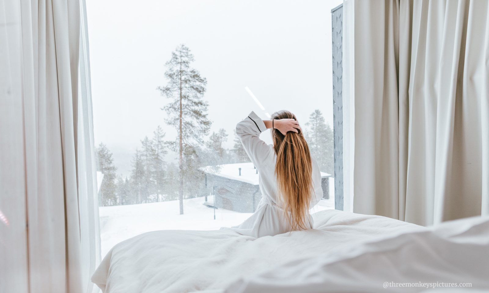 Woman gazing the snowy landscape from arctic scene executive suites.
