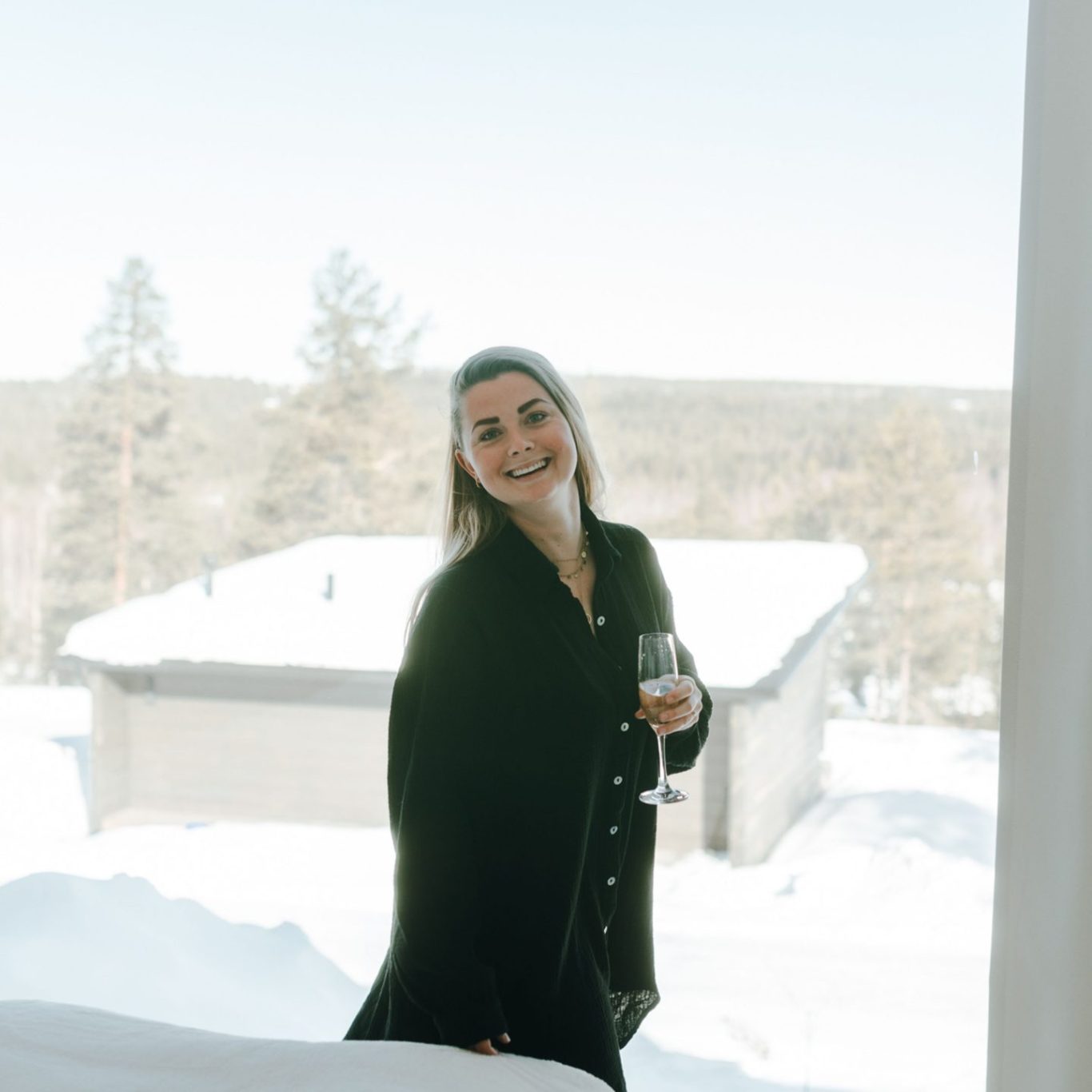 A woman smiling happily at suite in front of a arctic view