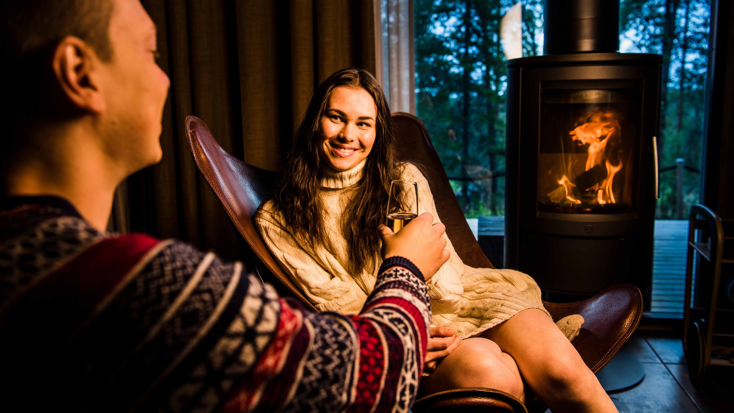 Couple enjoying arctic summer nights in a suite by the fire