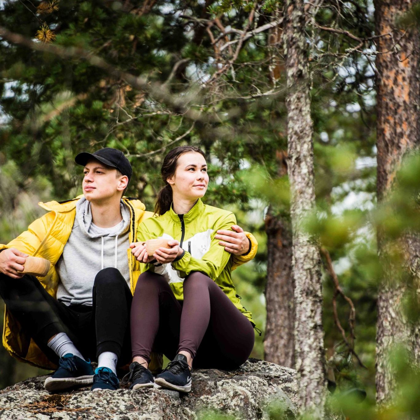 A couple having a break in northern forest during the hike.