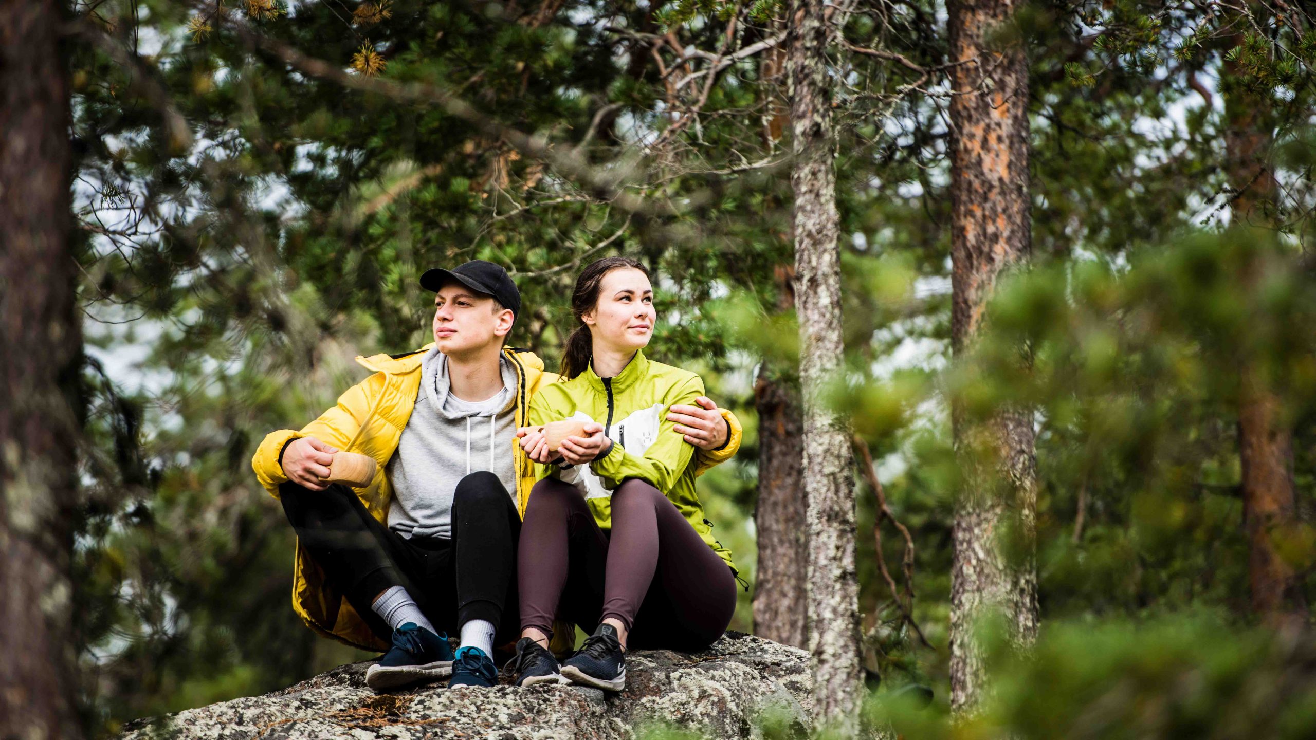 A couple having a break in northern forest during the hike.