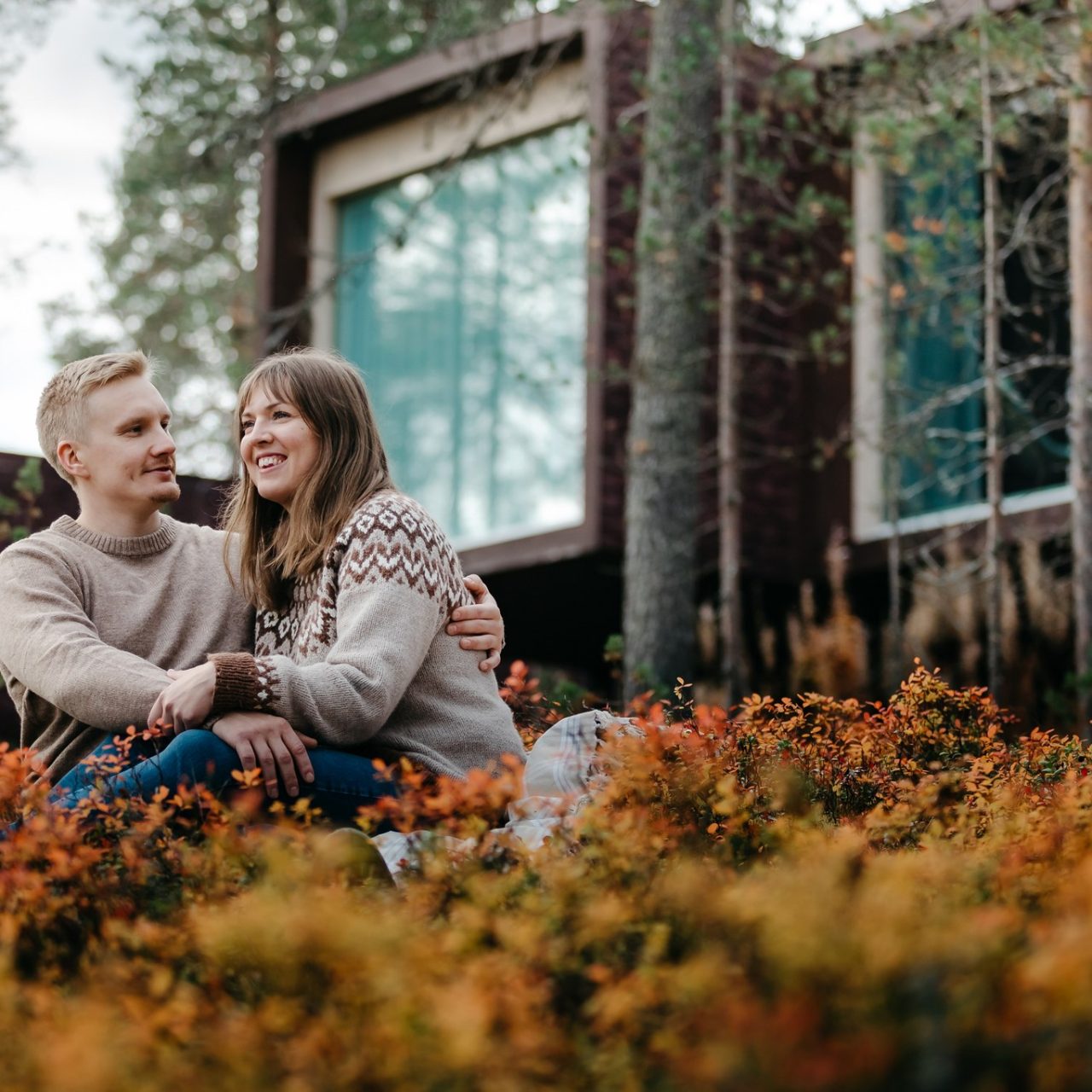 Couple enjoying autumn in front of Arctic TreeHouse Hotel suites.