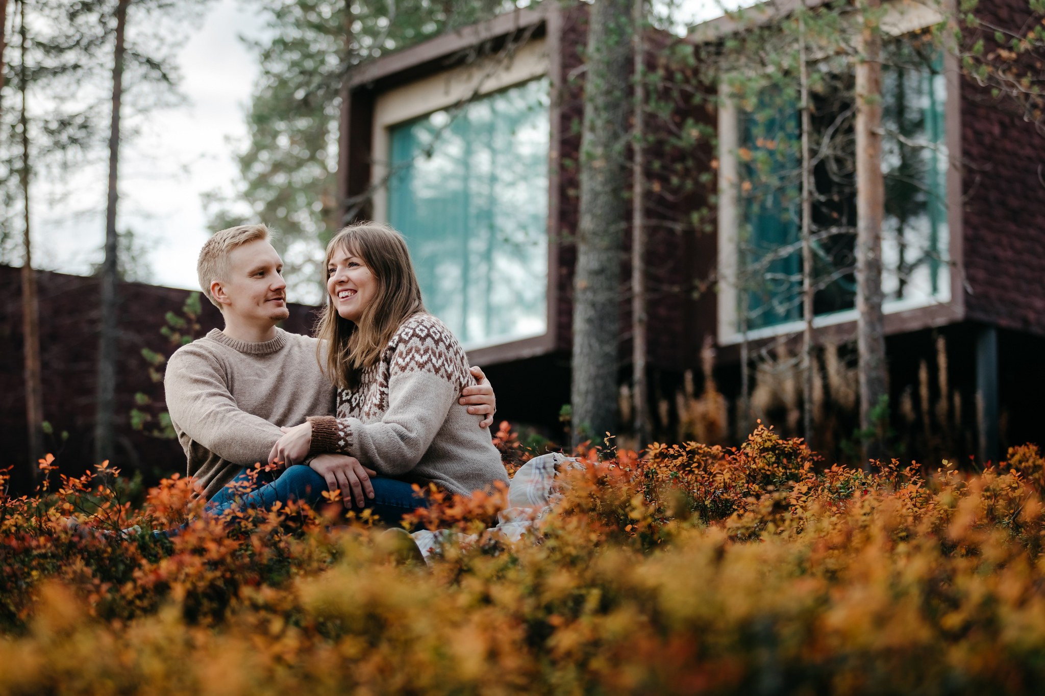Couple enjoying autumn in front of Arctic TreeHouse Hotel suites.