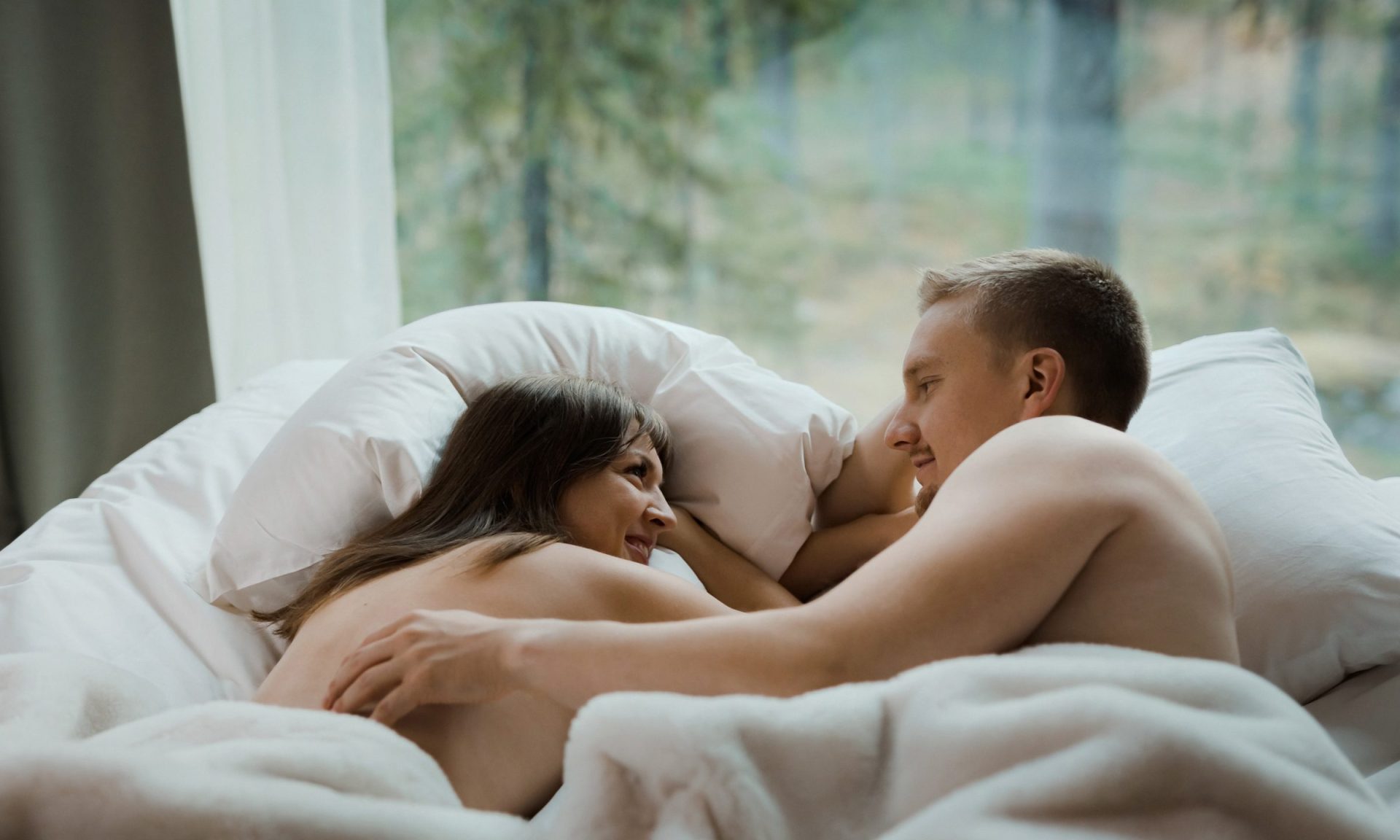 Couple enjoying long morning in bed at Arctic TreeHouse Hotel