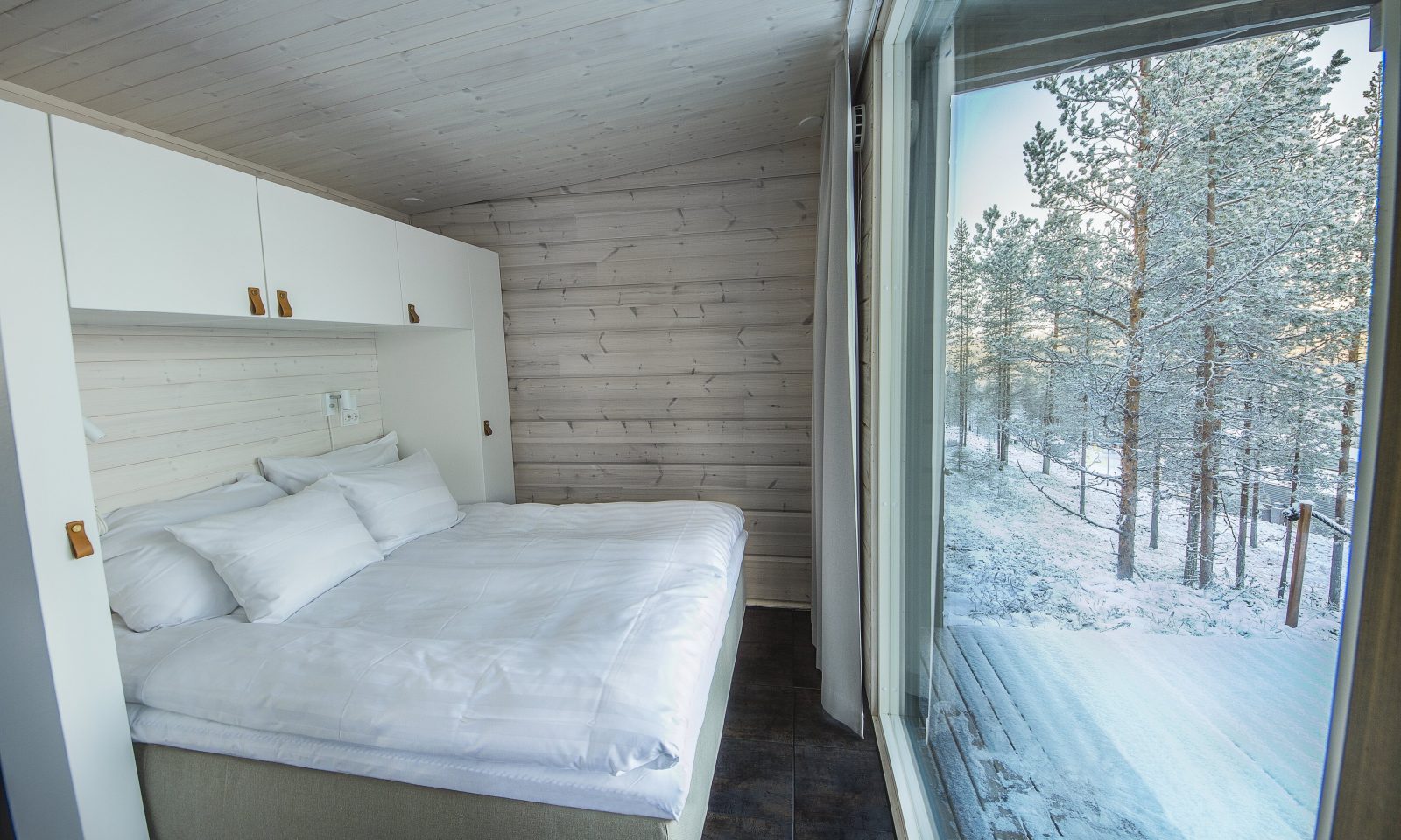 Arctic Glass Housen makuuhuone panorama-ikkunoilla pohjoiselle taivaalle.