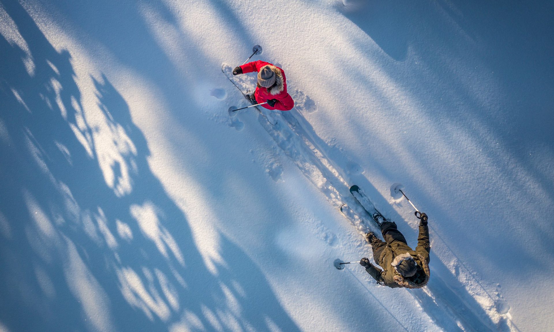 Nainen ja mies lumikenkäilemässä Lapin luonnossa.