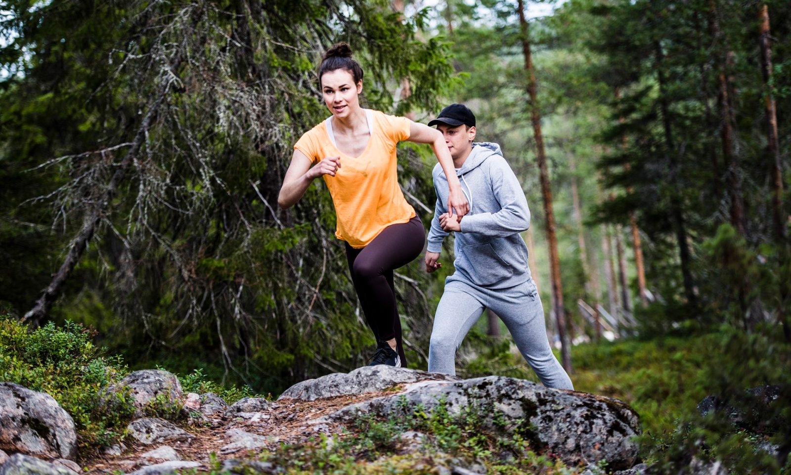 Couple running in the Lappish forest.