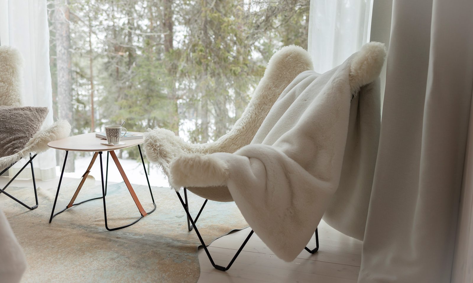 Arctic TreeHouse Suiten nojatuolit ja näkymä pohjoiselle taivaalle.