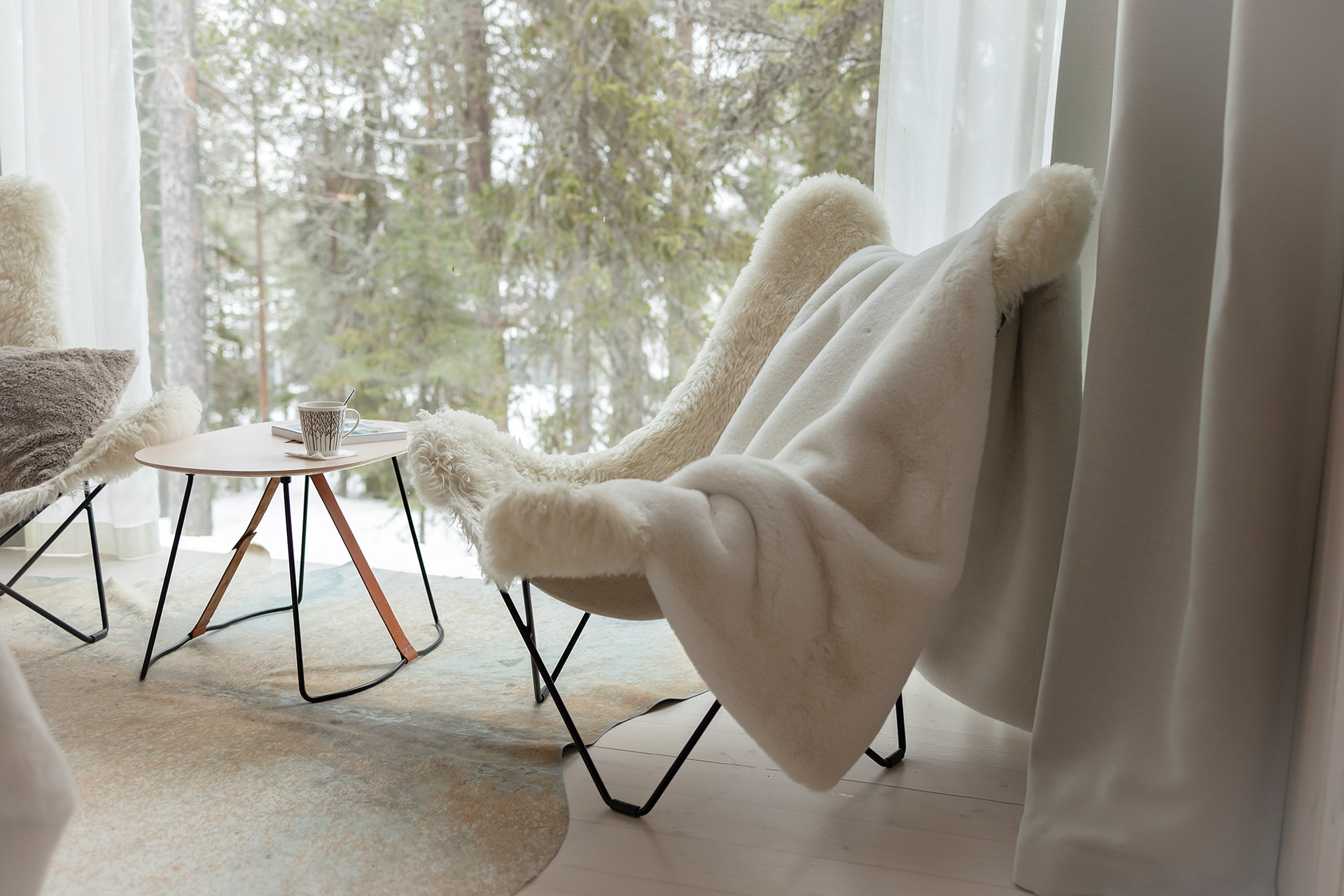 Arctic TreeHouse Suiten nojatuolit ja näkymä pohjoiselle taivaalle.