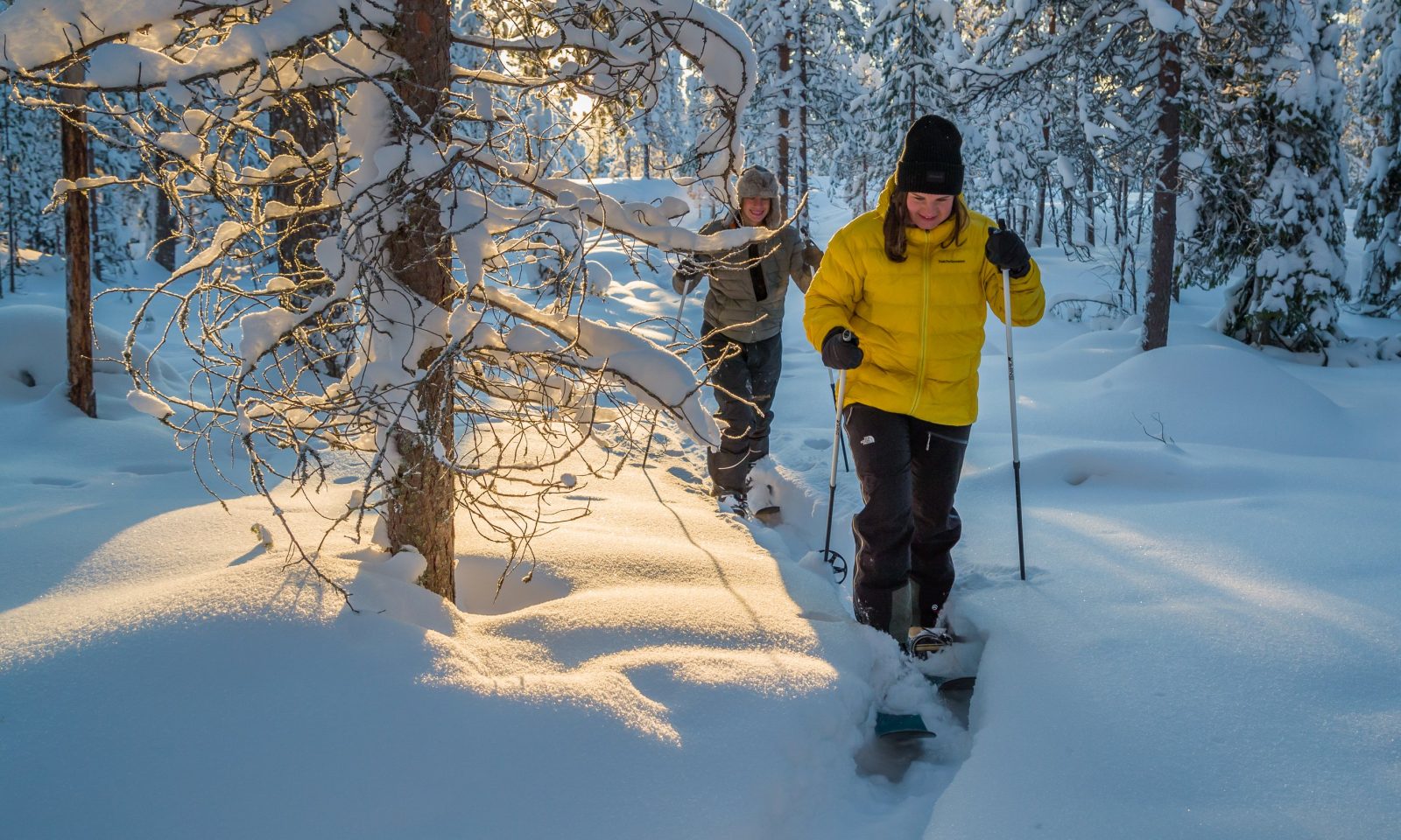 Couple snowshoeing in winter at Arctic TreeHouse Hotel.