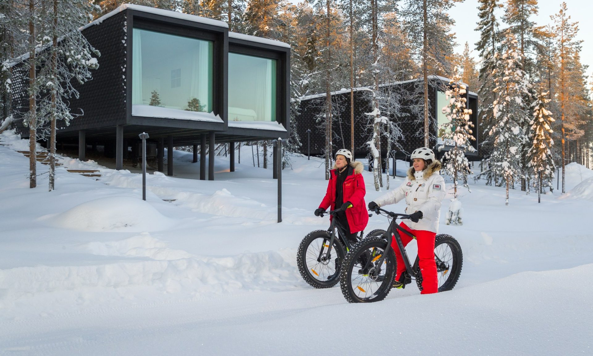Couple fatbiking in the premises of Arctic TreeHouse Hotel.