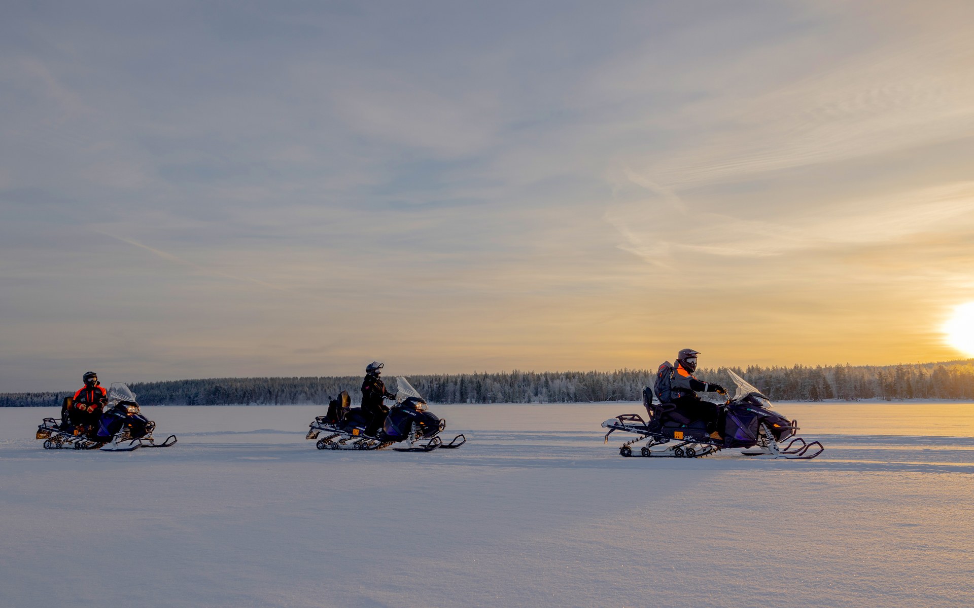 People enjoying e-snowmobile activity in Rovaniemi by Arctic TreeHouse Hotel.