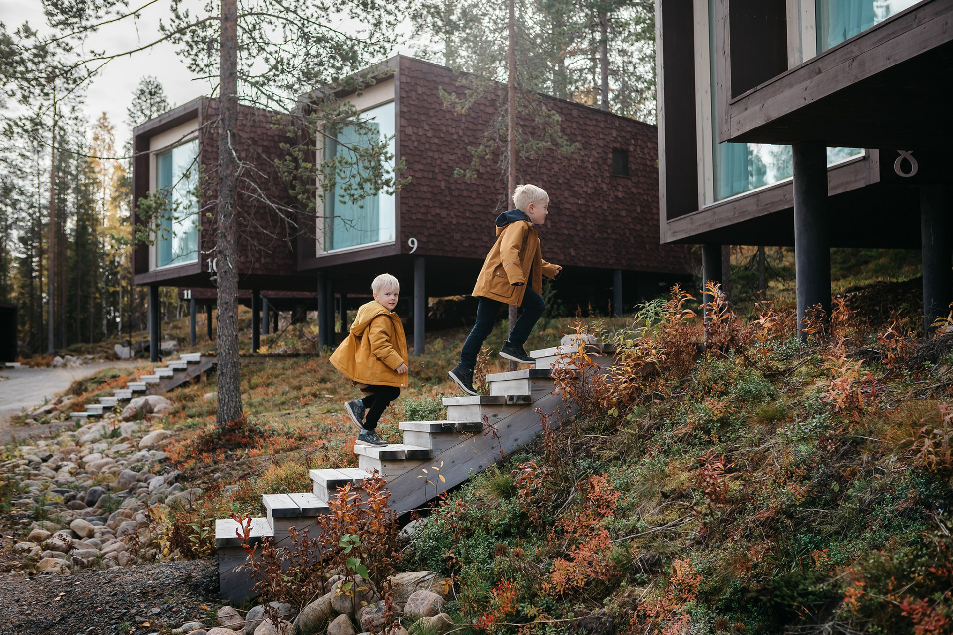 Two children heading to Arctic TreeHouse Suites in autumn.