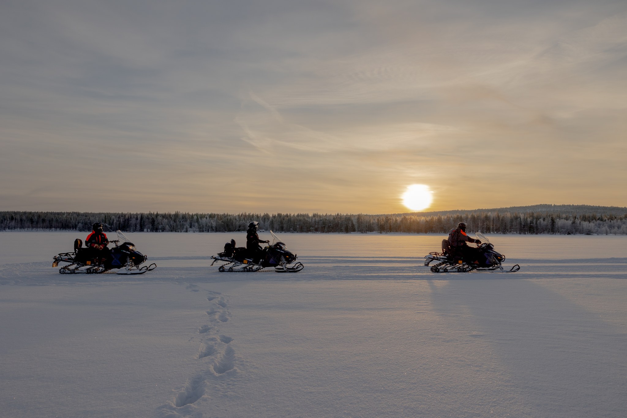 Private group snowmobiling in the frozen lake in Rovaniemi. | Arctic TreeHouse Hotel