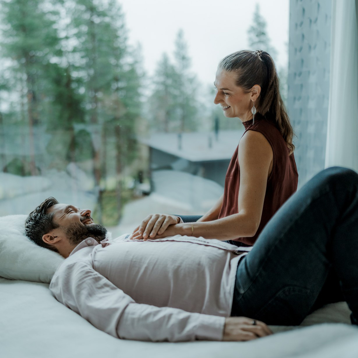 Couple relaxing in the comfort of Arctic Scene Executive Suite at Arctic TreeHouse Hotel, Rovaniemi.