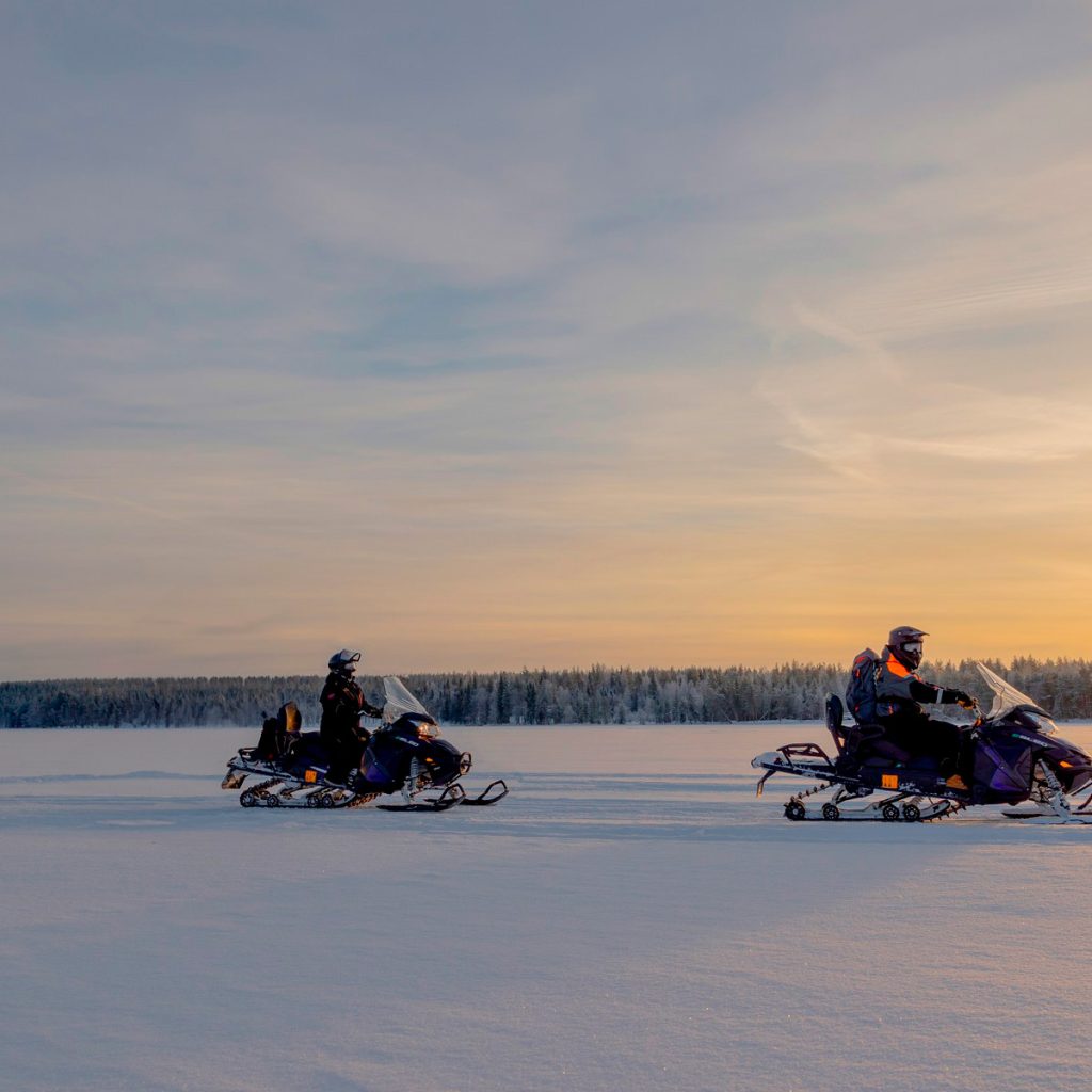 Group snowmobiling in Rovaniemi in winter. | Arctic TreeHouse Hotel.