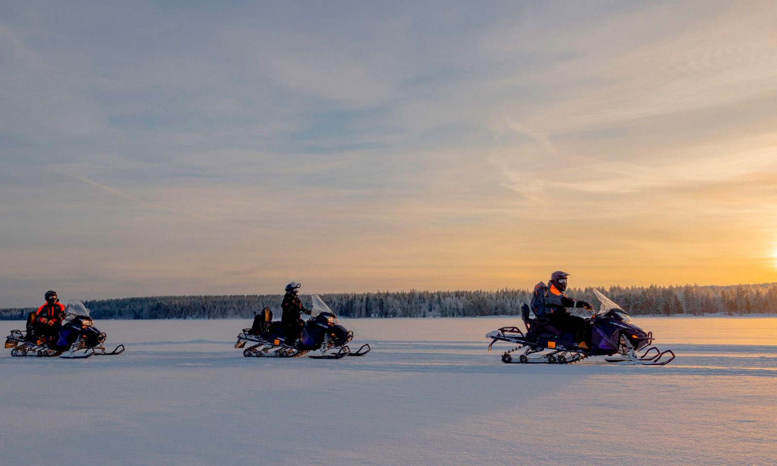 Group snowmobiling in Rovaniemi in winter. | Arctic TreeHouse Hotel.