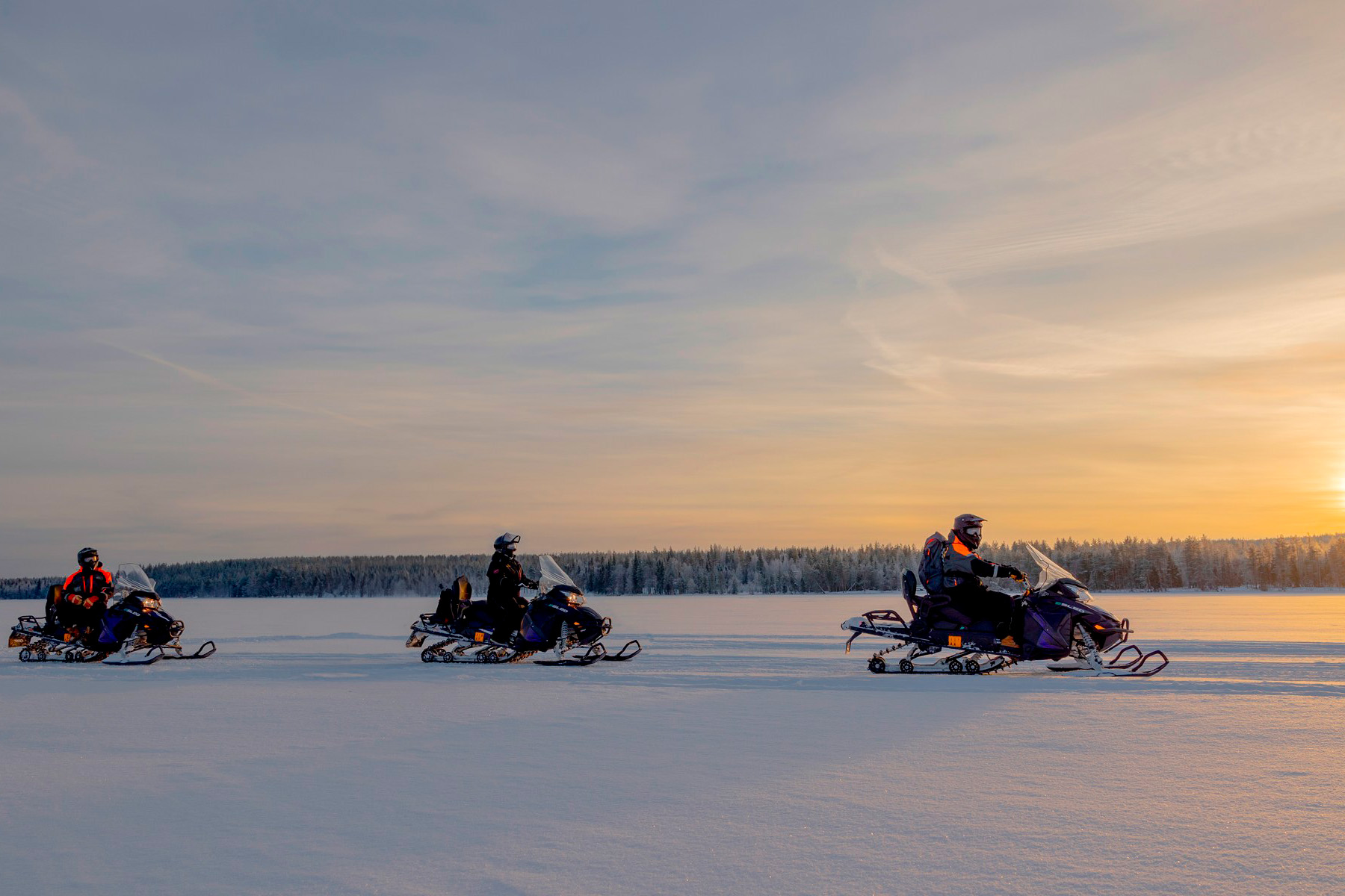 Group snowmobiling in Rovaniemi in winter. | Arctic TreeHouse Hotel.