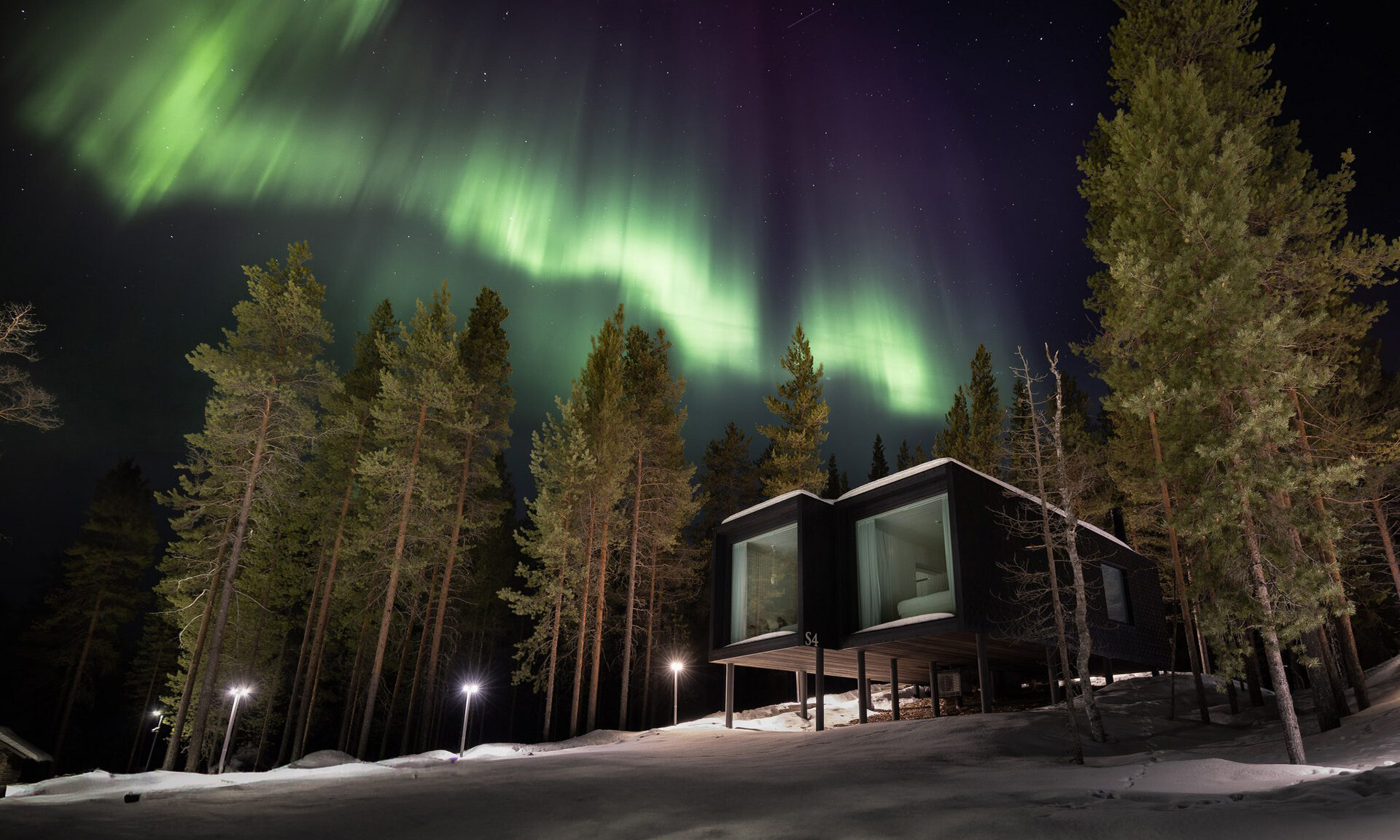 Northern Lights dancing above Arctic Scene Executive Suites. Rovaniemi, Lapland, Finland.