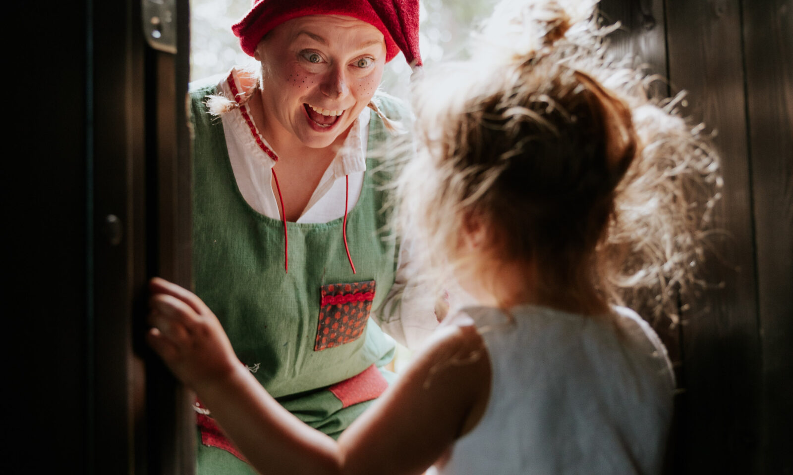 An Elf greeting a young guest inside an Arctic TreeHouse Hotel suite in Rovaniemi, Lapland.